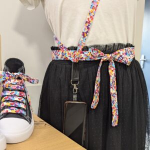 Ensemble d'accessoires fleuris multicolores comprenant ceinture, lanière pour téléphone et lacets, porté pour un style unique et coloré