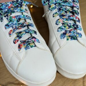 lacets fantaisie en tissu moucheté vert et bleu sur baskets blanches