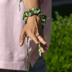 chouchou en tissu vert et rose porté au poignet