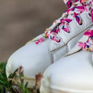 lacets rose sur chaussures adidas blanches avec charms